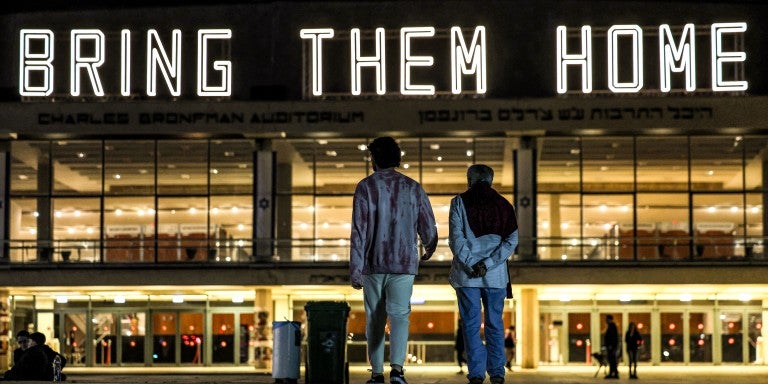 TOPSHOT - A neon sign reading "BRING THEM HOME", referring to the Israeli hostages held in Gaza since the October 7 attacks, is displayed atop the Charles Bronfman Auditorium (Heichal HaTarbut) at HaBima Square in Tel Aviv on December 9, 2023. Israeli forces have encircled major urban centres in the Gaza Strip as they seek to destroy Hamas over its unprecedented attack in October when militants broke through Gaza's militarised border to kill around 1,200 people and seize hostages, 138 of whom remain captive