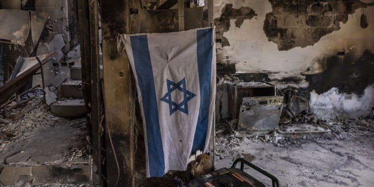 BE'ERI, ISRAEL - DECEMBER 20: Israeli flag hangs in destroyed house on December 20, 2023 in Be'eri, Israel. Families and supporters of hostages kidnapped by Hamas on Oct. 7 joined a tour of Kibbutz Be'eri held for journalists to mark 75 days since the attack. 