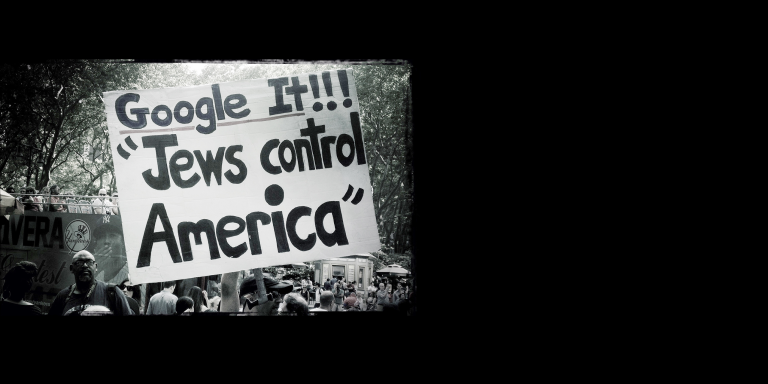 Black and White photo of a sign saying "Google it!! Jews control America"