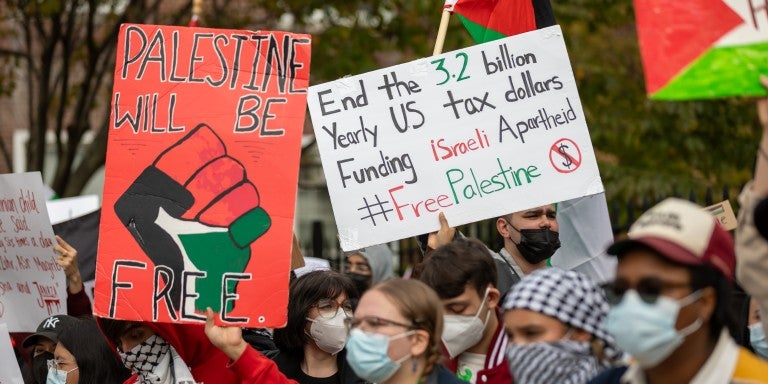 Signs in an SJP protest saying Palestine will be Free
