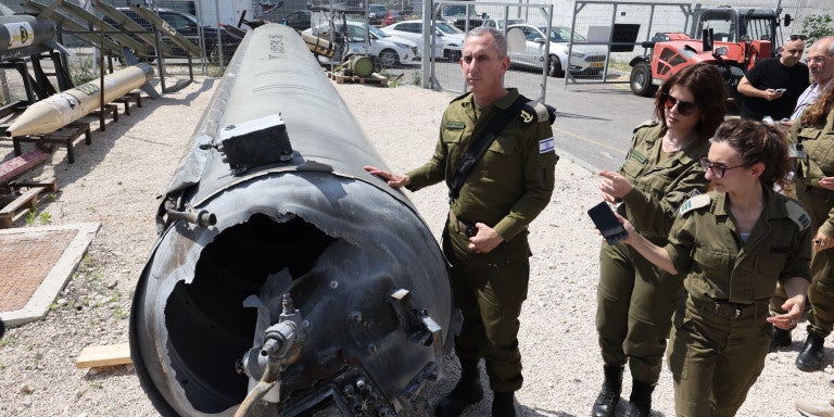 Israeli military spokesman Rear Admiral Daniel Hagari (C) and other members of the Israeli military stand next to an Iranian ballistic missile which fell in Israel on the weekend, during a media tour at the Julis military base near the southern Israeli city of Kiryat Malachi on April 16, 2024. Iran carried out an unprecedented direct attack on Israel overnight April 13-14, using more than 300 drones, cruise missiles and ballistic missiles.