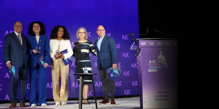Image of Bill, Susan, and Josh Greene presenting the AJC Sharon Greene Award for Campus Advocacy to Hannah Veiler and Noa Fay at AJC's 2024 Global Forum