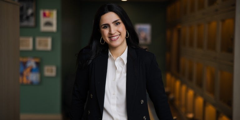 Dr. Mijal Bitton, dressed in a black blazer and yellow skirt and smiling.