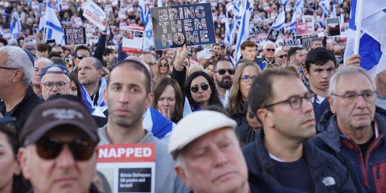 Crowd holding a Bring Them Home signs