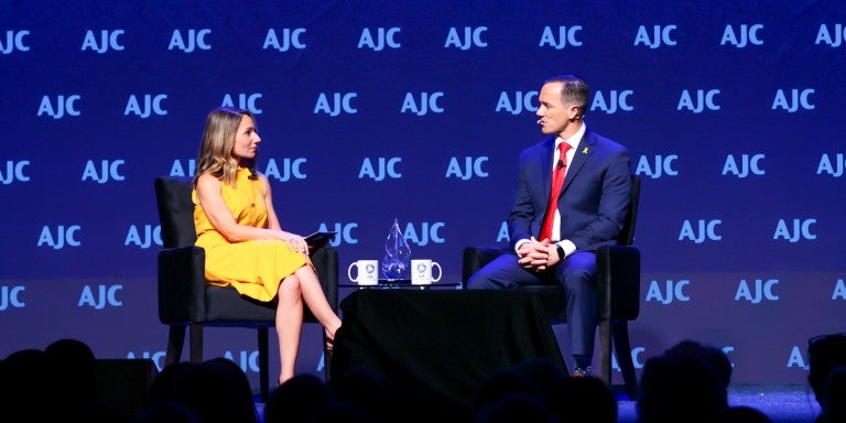 Casey Kustin and John Spencer speaking on AJC Global Forum stage