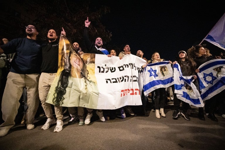People celebrate the release of Isreali hostages from Hamas captivity at Sheba Medical Center in Ramat Gan, Israel, Jan. 19, 2025. Three Israeli women, released from Hamas captivity in Gaza, arrived in Israel on Sunday, the first day that a ceasefire agreement between Israel and Hamas took effect, according to Israeli officials. The three -- Emily Damari, 28, a British-Israeli; Doron Steinbrecher, 30, a veterinary nurse; and Romi Gonen, 23, abducted from the Nova music festival -- were finally released afte