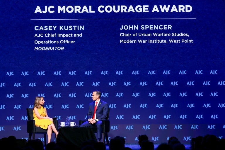 Casey Kustin and John Spencer speaking on AJC Global Forum stage