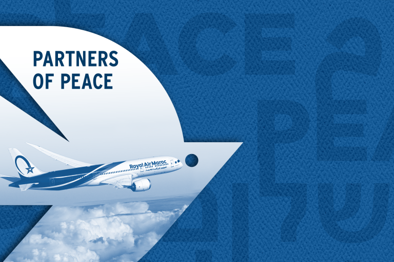 White dove over a dark blue background with peace written in three languages: Hebrew, Arabic, and English. Photo inside the dove reads "Partners of Peace" and shows an image of a Royal Air Maroc plane in flight, over clouds.