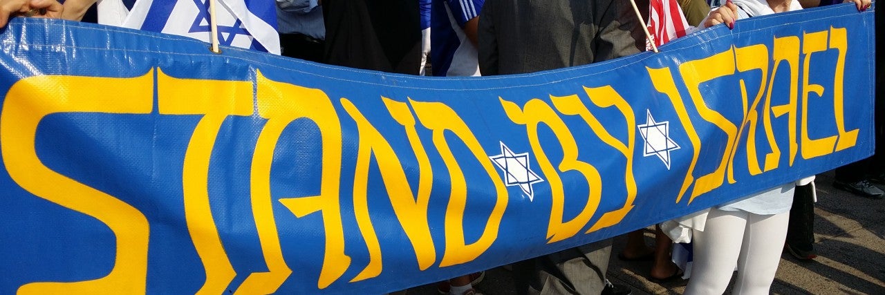 Photo of a parade banner displaying Stand by Israel