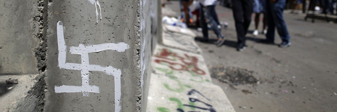 Photo of graffiti of a Star of David and a Swastika