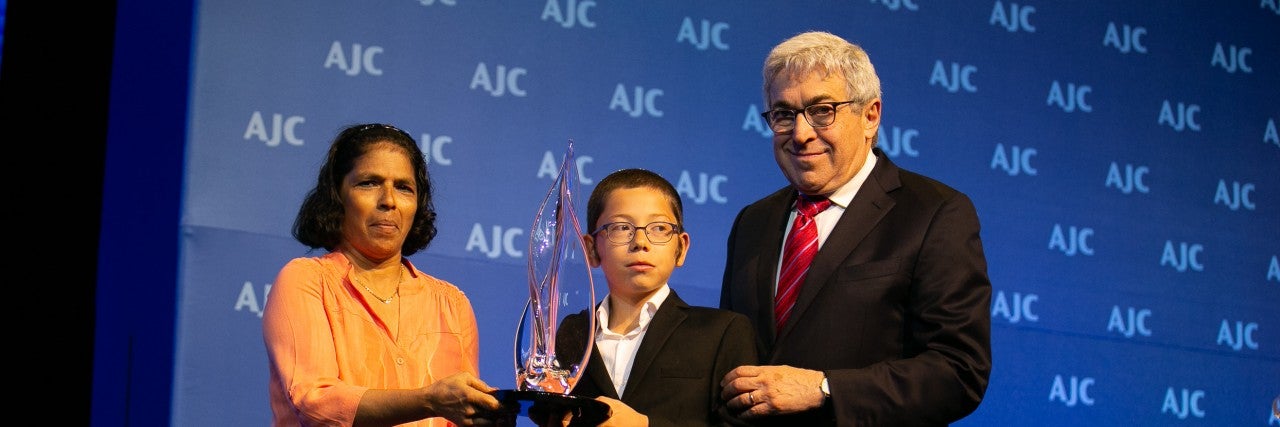 Photo of Sandra Samuel receiving the AJC Moral Courage Award with Former-AJC President Stanley M. Bergman and Moshe Holtzberg
