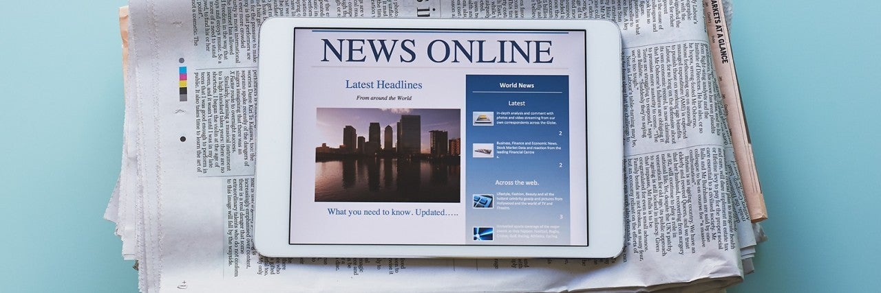 iPad saying "News Online" with a newspaper behind