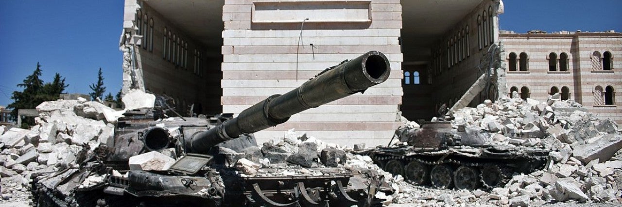 Two destroyed tanks in front of a mosque in Azaz, Syria
