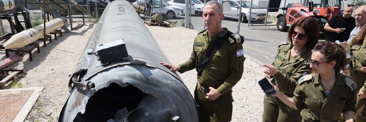 Israeli military spokesman Rear Admiral Daniel Hagari (C) and other members of the Israeli military stand next to an Iranian ballistic missile which fell in Israel on the weekend, during a media tour at the Julis military base near the southern Israeli city of Kiryat Malachi on April 16, 2024. Iran carried out an unprecedented direct attack on Israel overnight April 13-14, using more than 300 drones, cruise missiles and ballistic missiles.