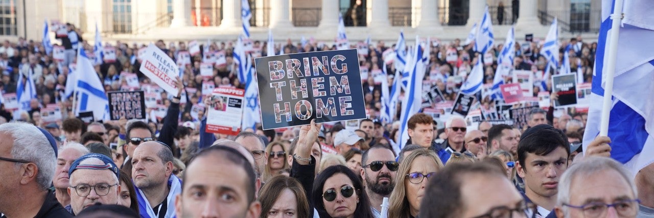 Crowd holding a Bring Them Home signs