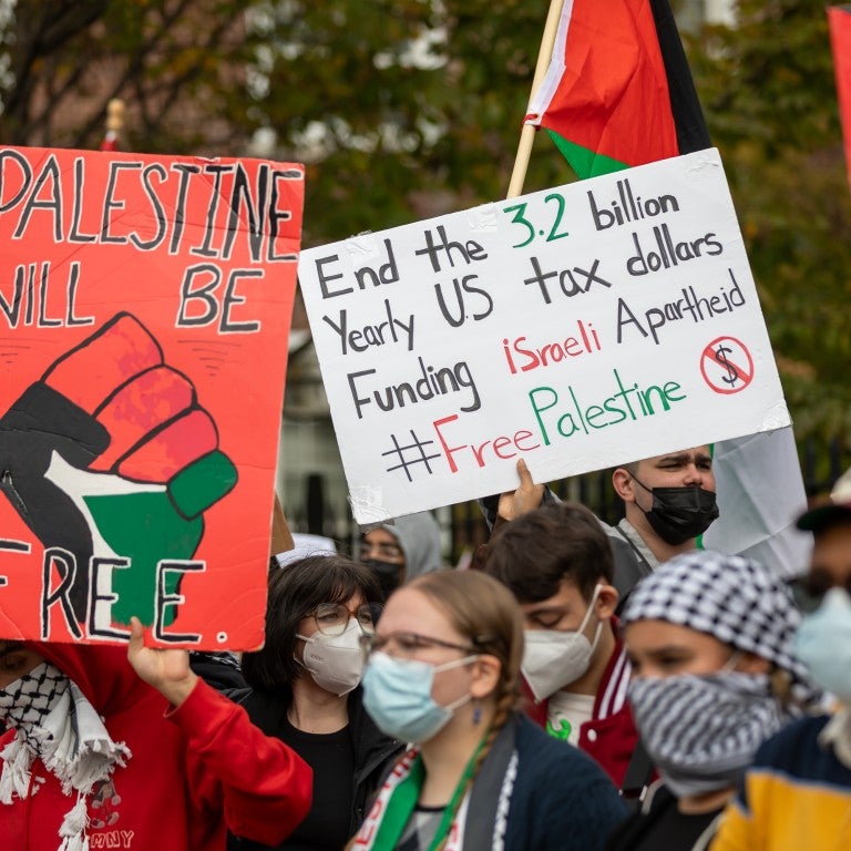 Signs in an SJP protest saying Palestine will be Free