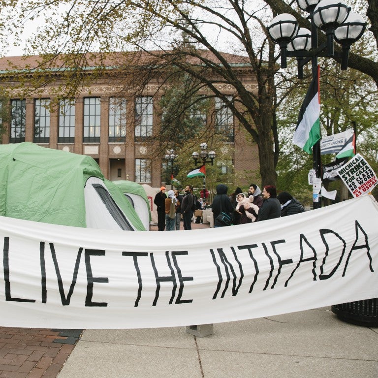 Photo of encampment with a sign saying Long Live the Intifada